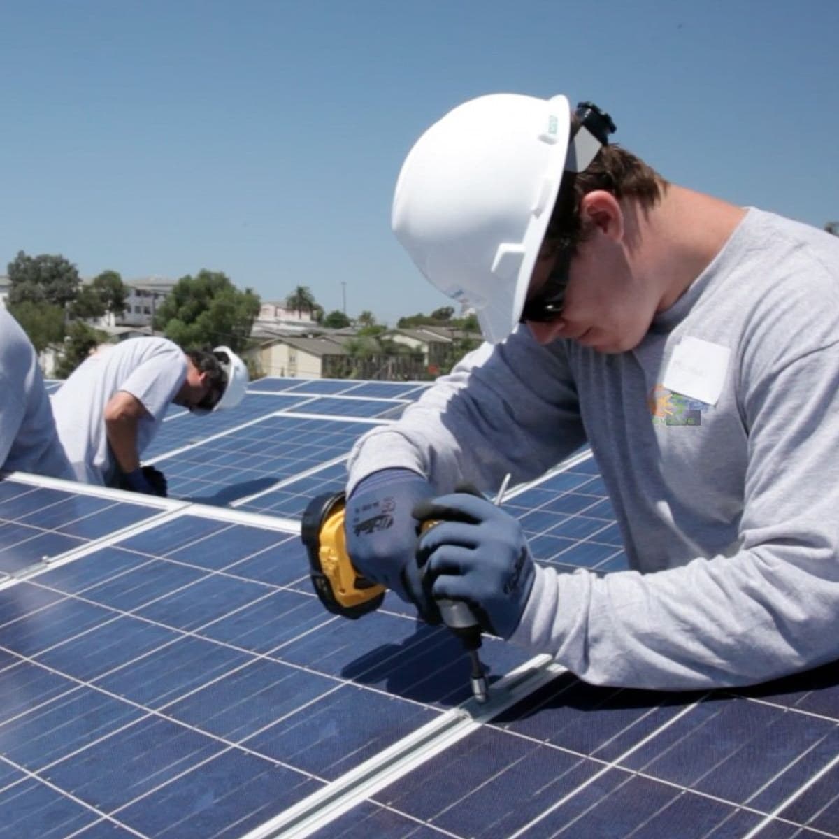 Installation crew securing panels on a rooftop array