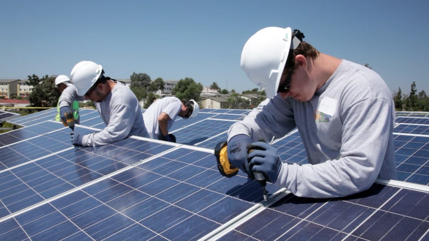 Certified installation crew securing panels on a commercial rooftop