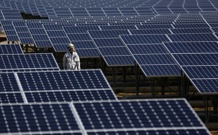 Technician inspecting a large solar array